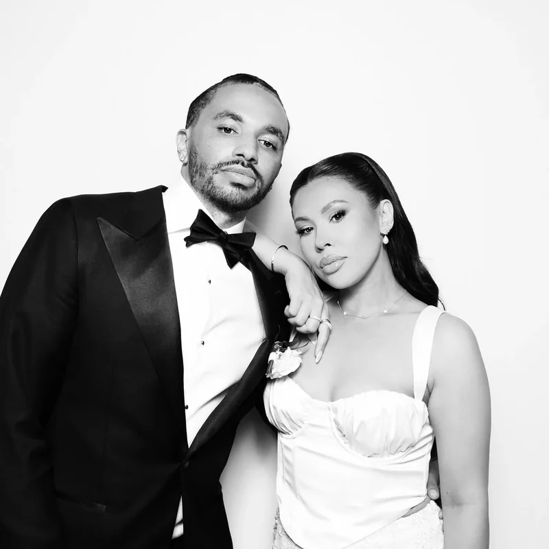 A couple in a tuxedo and bridal dress in a classic black and white portrait.