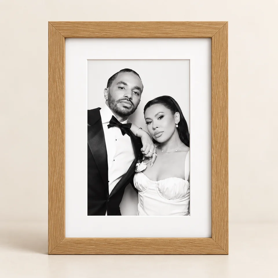Light wood frame with a white mount and a black and white wedding portrait.
